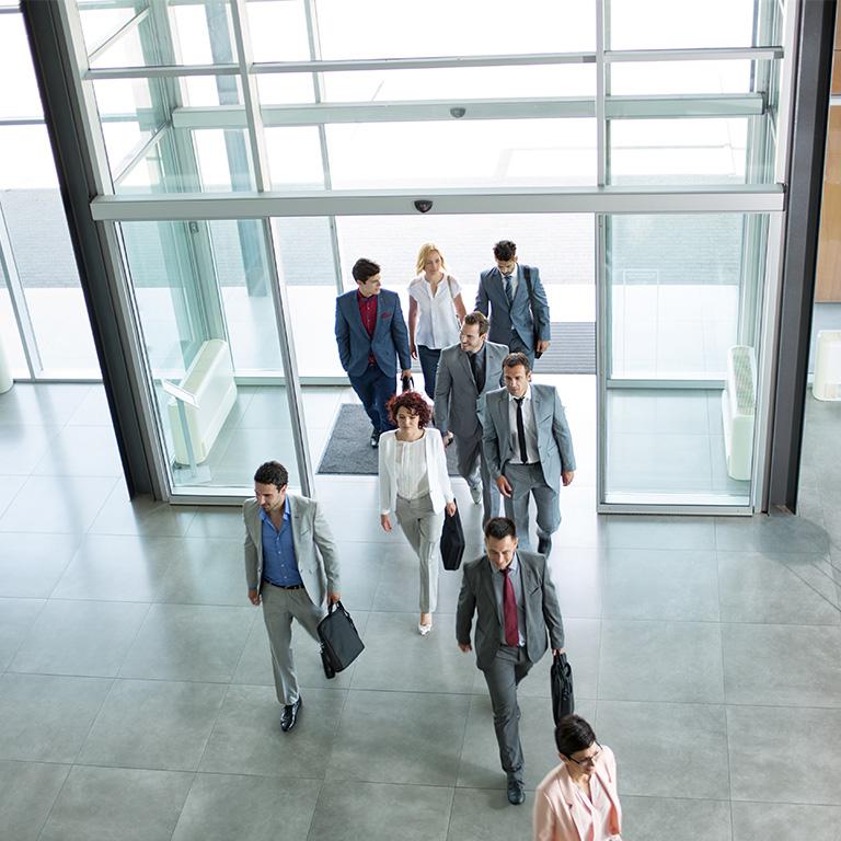 people in suits walking into a building