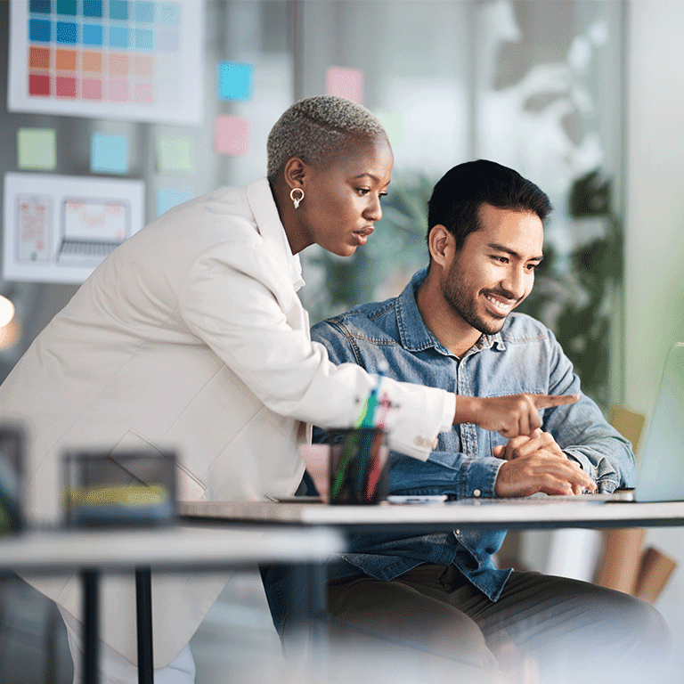 co workers gathered around a laptop