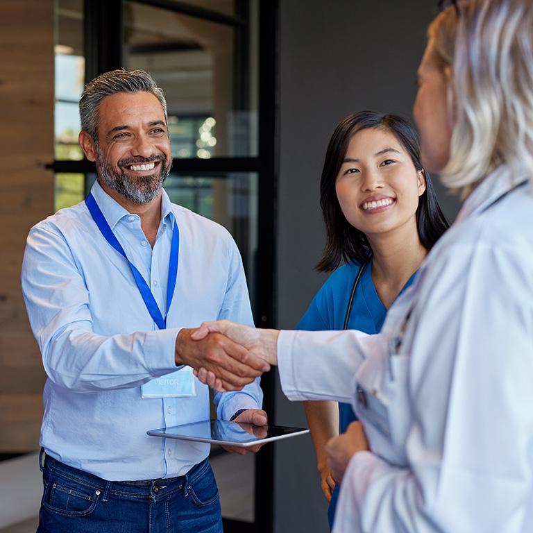 Doctors and employees shaking hands and smiling