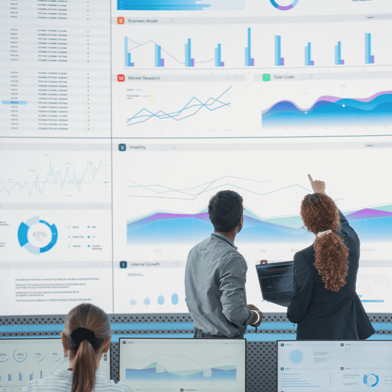 two people looking over charts projected onto the wall