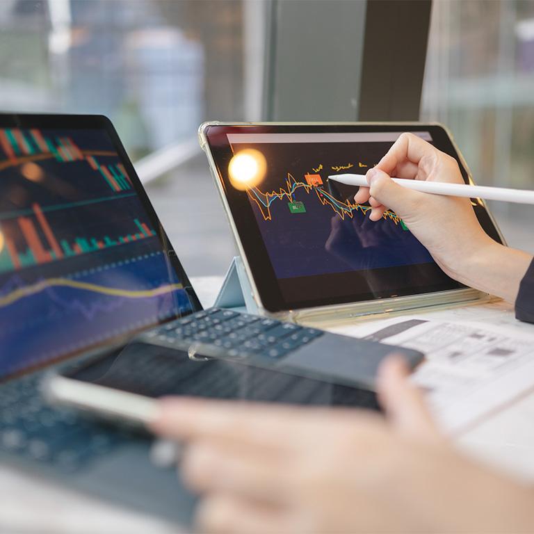 hand using stylus on a tablet with charts on it