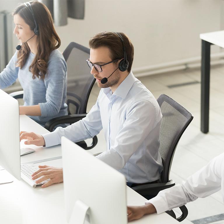 person with headset working on a computer