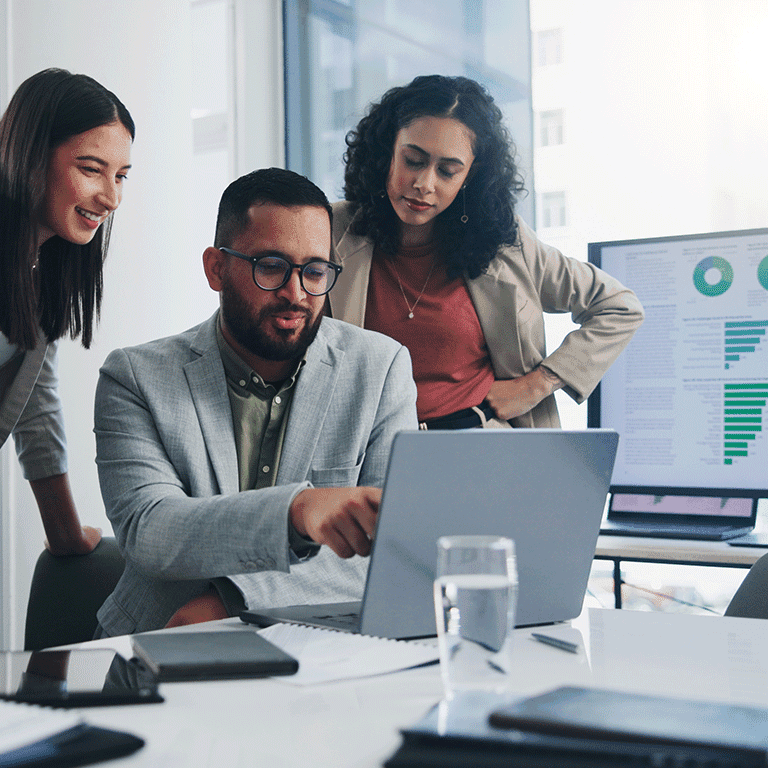 co workers gathered around a laptop