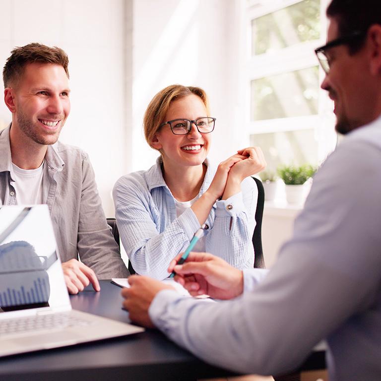 couple at a table talking to a man in glasses