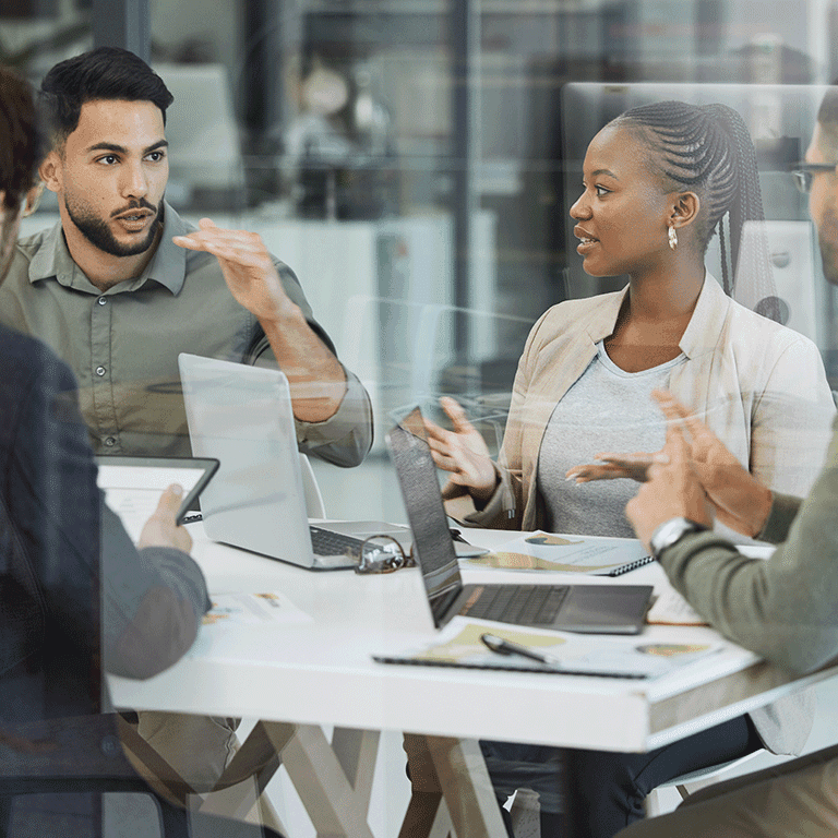 co workers gathered around a table viewed through a window